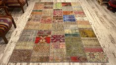 a multicolored patchwork rug is on the floor next to a chair and two chairs