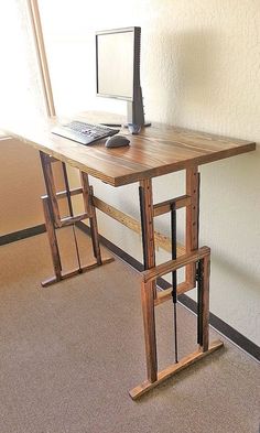 a desk with a computer on it in an empty room next to a chair and window