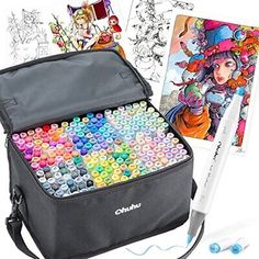 a bag filled with lots of colorful crayons next to a drawing book and markers