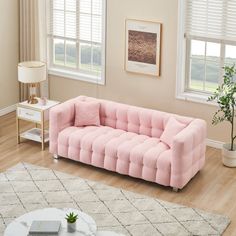 a living room with pink couches and white rugs on the hardwood flooring