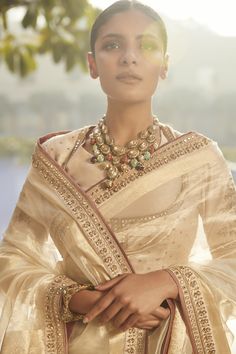 Editor's Note Experience sheer elegance with our Suchcha Ekru Old Benaras Wrinkled Tissue Saree, a masterpiece of grace and royalty. Crafted from wrinkled ivory tissue with golden borders adorned with Resham and Zardozi handwork, it exudes opulence. The minimalist opulence of Signature Matsya Delicacy shines through in this ensemble. The blouse, featuring a scooped neckline, showcases its utter royalty and is crafted from silk Chanderi with full sleeves, border details, sequin sprinklers, and mo Tissue Saree, White Saree, Scooped Neckline, Saree With Blouse, Designer Gowns, Full Sleeves, Every Girl, Saree Blouse, Aza Fashion