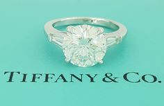 an oval and baguette cut diamond ring on a tiffany & co card board