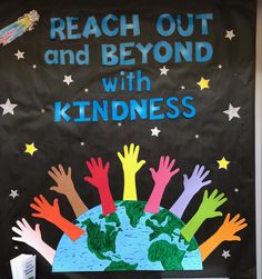 a bulletin board with children's hands on top of the earth and stars above it