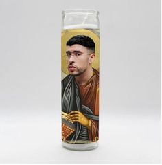 a candle with an image of a man holding a gold cross on it's side