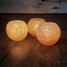 three himalayan salt lamps sitting on top of a wooden table