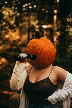 a woman wearing a pumpkin hat drinking from a bottle