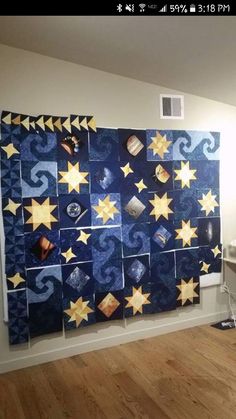 a room with a wall hanging made out of quilts