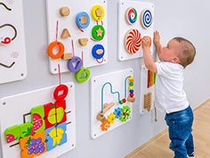 a little boy playing with magnets on the wall