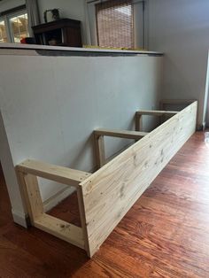 a wooden bed frame sitting on top of a hard wood floor next to a wall