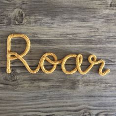 the word rock written in rope on a wooden surface