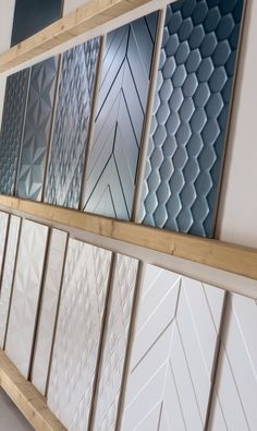 several different types of tile on display in a room with wooden shelves and white walls