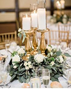 a table topped with lots of white flowers and candles