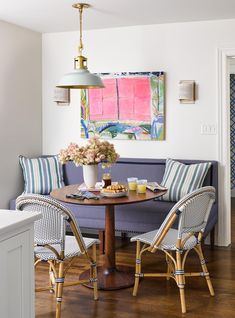 a living room filled with furniture and a painting on the wall above it's coffee table