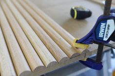 a pair of pliers are sitting on top of a wooden slatted bench