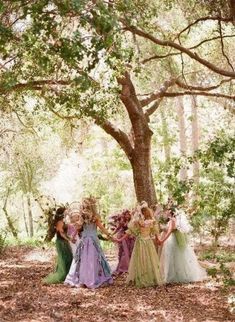 a group of women standing next to each other under a tree