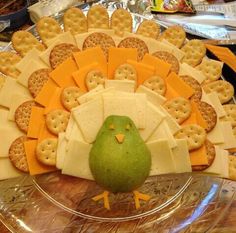 a turkey made out of crackers and cheese on a platter with a green bird