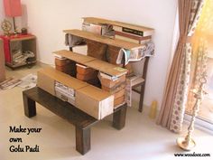 a table made out of cardboard boxes and other items in a living room with a window behind it