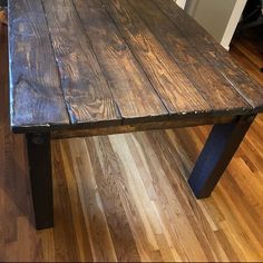 a wooden table sitting on top of a hard wood floor