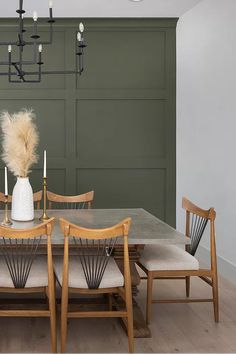 a dining room table with chairs and a vase on it