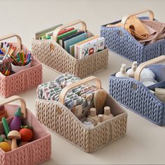 four baskets filled with toys on top of a white table next to other containers and items