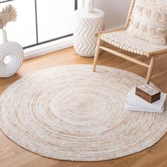 a living room with a chair, rug and vases on the hardwood flooring