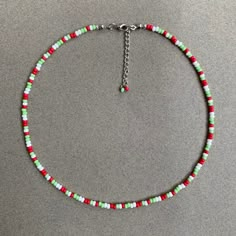 a red, green and white beaded necklace on a silver chain