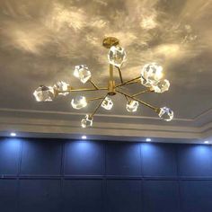 a chandelier hanging from the ceiling in a room with blue walls and lights