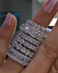 a woman's hand with three stacked rings on her fingers and one ring in the middle