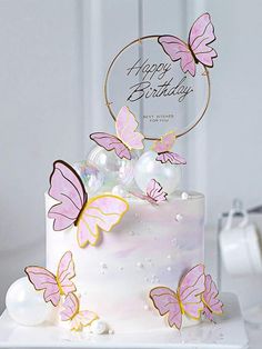 a white cake with pink butterflies on it and a happy birthday card in the middle