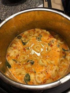 a pot filled with pasta and sauce on top of a stove