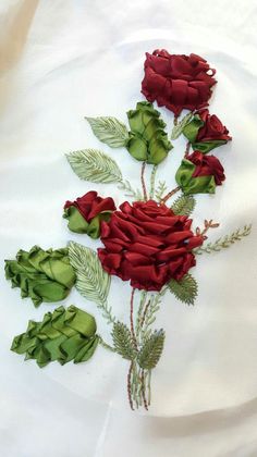 red roses and green leaves on white fabric