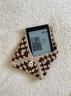 an electronic device sitting on top of a white carpet next to a book holder with a button