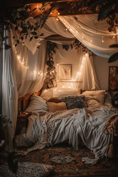 an unmade bed with white curtains and lights on the headboard is lit up by fairy lights