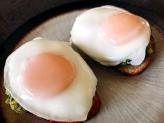 two eggs are sitting on top of toast