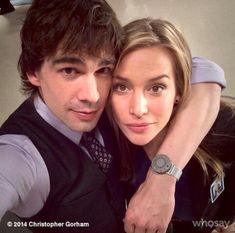 a young man and woman posing for a photo together with their arms around each other