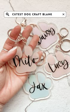 someone holding onto some key chains with their names on them and hearts in the middle