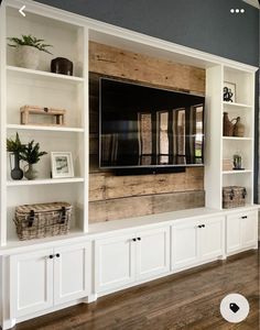 an entertainment center with built - in shelving and baskets