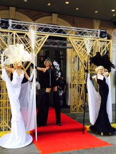 two women dressed in black and white are walking down the red carpeted entrance to an event