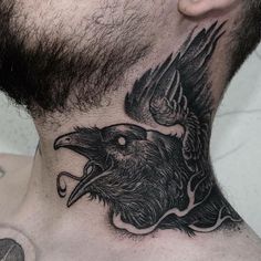 a man's neck with a bird tattoo on it