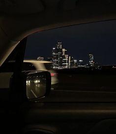 the view from inside a car at night with city lights in the background