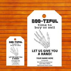 two tags with skeleton hands on them are attached to a wooden wall that says boo - tiful time to buy or sell let us give you a hand