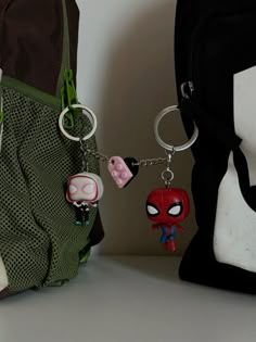 the spider - man keychain has been placed next to a bag with other items on it