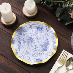 a blue and white plate sitting on top of a wooden table next to two candles