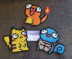 four pixel art magnets sitting on top of a table