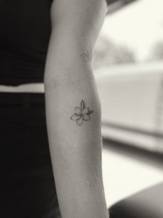 a woman with a small flower tattoo on her arm