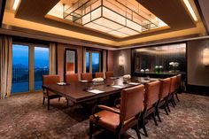 a large dining room table and chairs in front of windows