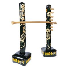 two black and gold musical instrument stands with skulls on them, one holding a wooden stick