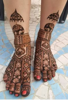 two feet with henna tattoos on them, one is holding an umbrella and the other has