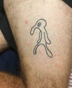 a man with a tattoo on his leg that has scissors in the shape of a letter