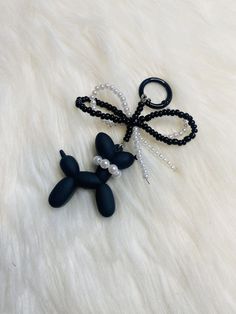 a black and white beaded dog keychain with pearls on it's tail